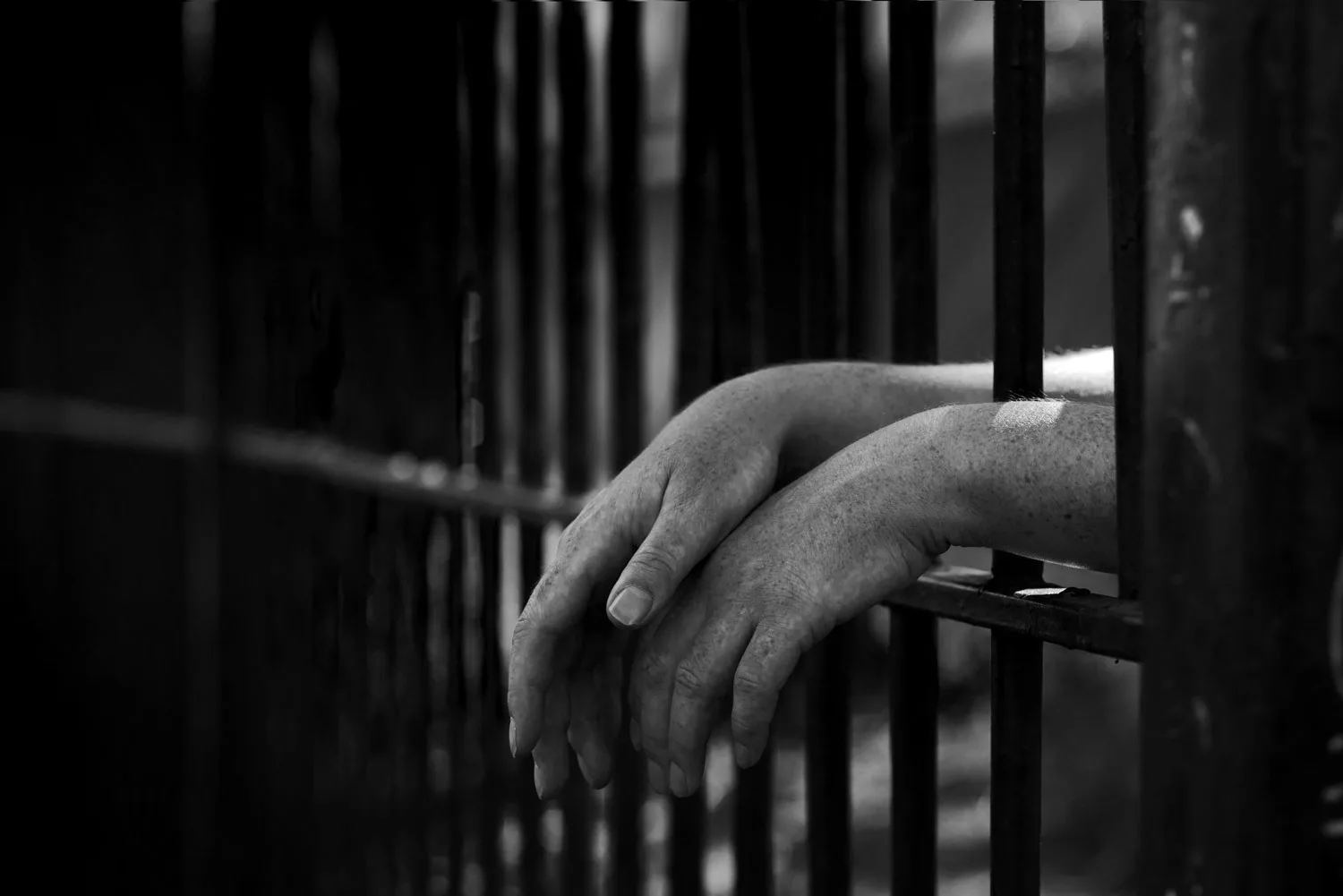 Hands gripping prison bars — a metaphor for businesses trapped by outdated ERP systems